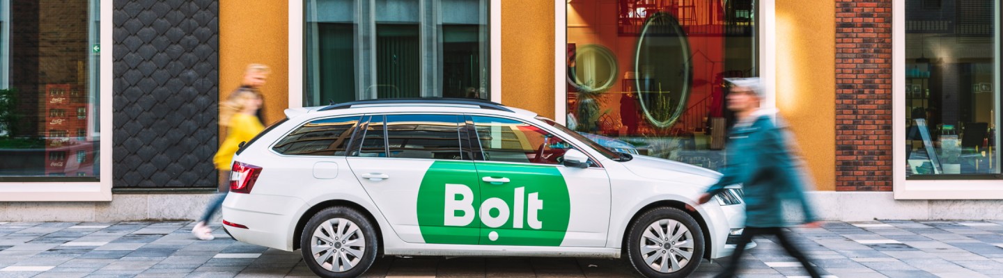 Bolti auto kollase fassaadi ja roheliste ustega maja ees